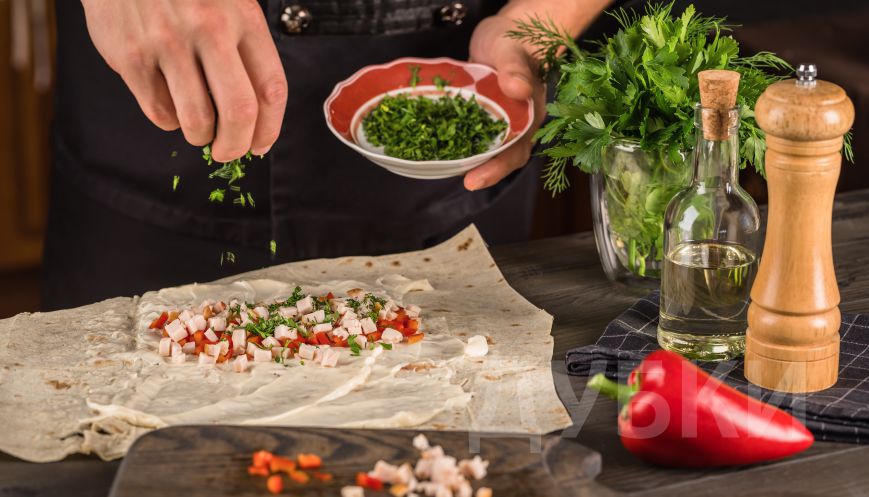 Поверх сыра разложить порезанную куриную грудку, перец и зелень.